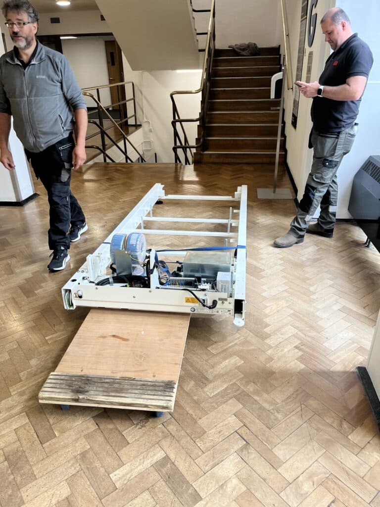 The HaB direct team take the disassembled treadmill up stairs at the university of westminster